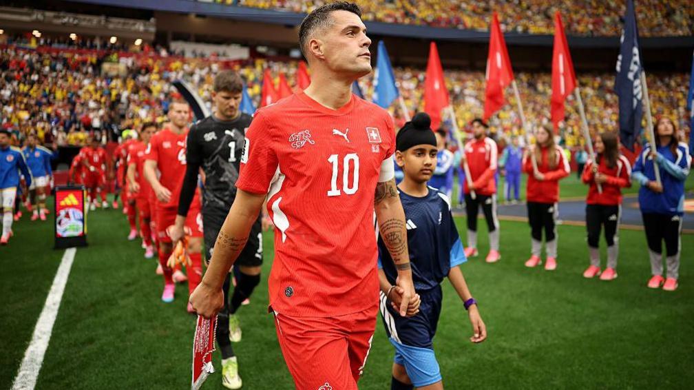 Granit Xhaka leads out Switzerland onto the pitch