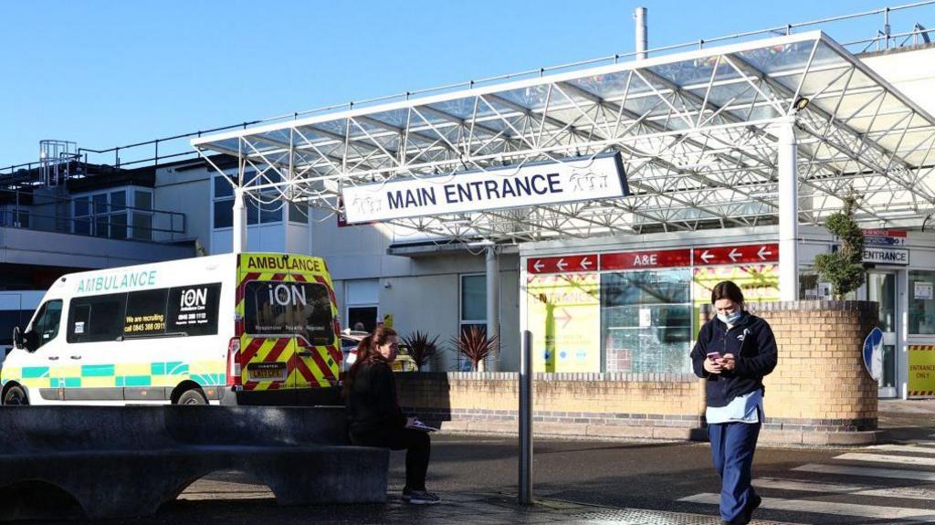 A member of the hospital personnel walks outside Frimley Park Hospital in Surrey on 13 January 13 2022.