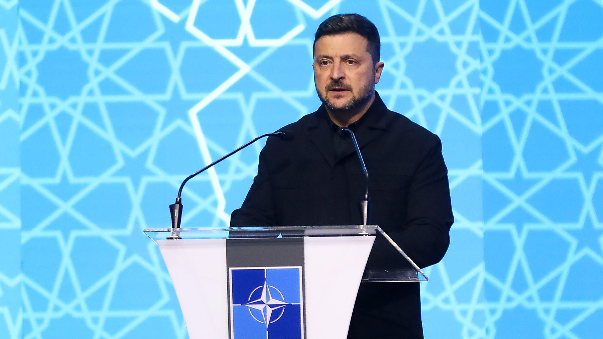 Zelensky leaves the podium holding a binder of notes
