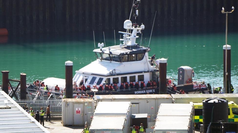 a Border Force boat with a crowd of people wearing life jackets