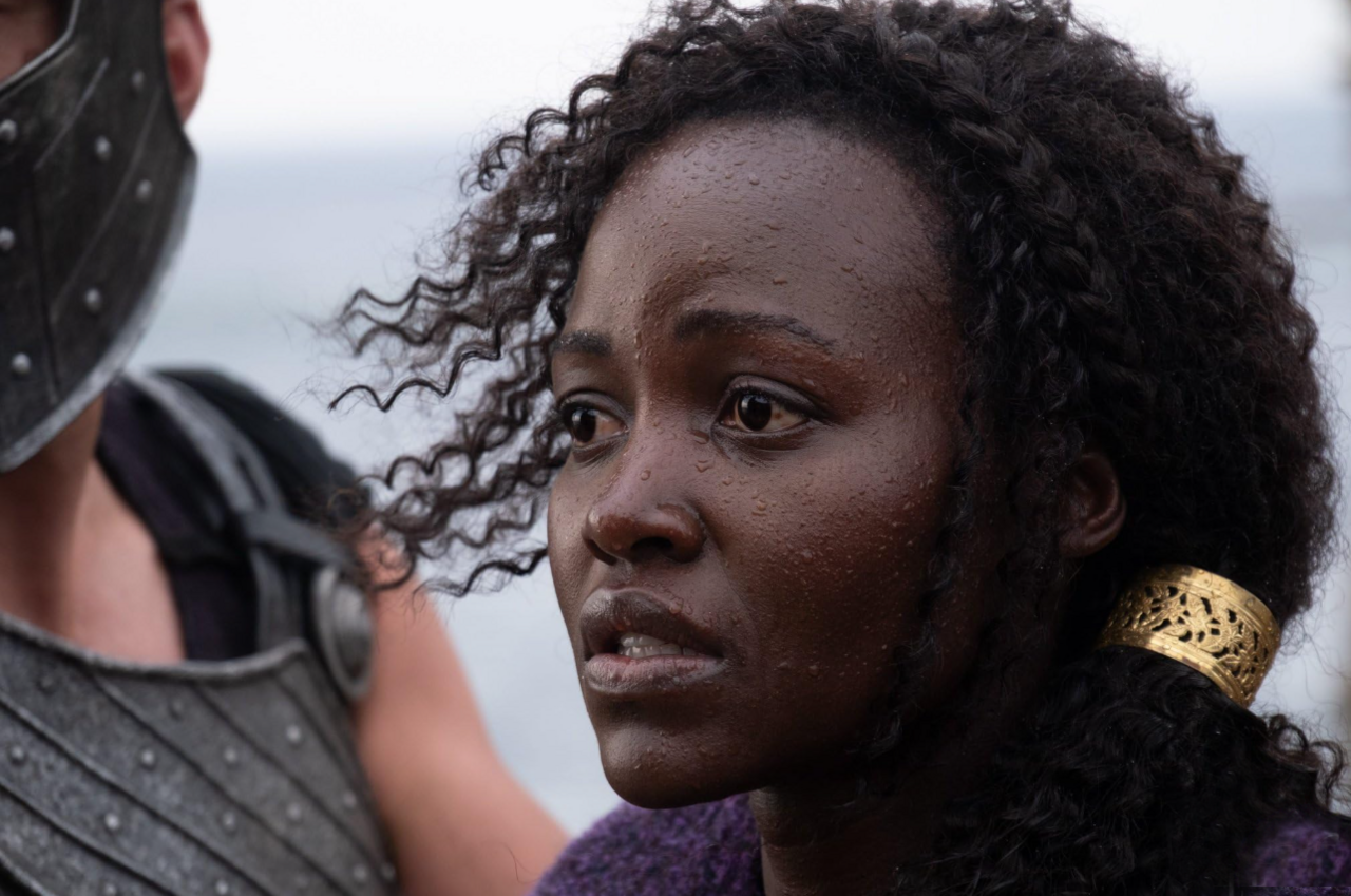 Lupita Nyong'o looks to the left of frame in a concerned manner, in a close head and shoulders shot as she stars as Helen of Troy in Christopher Nolan's The Odyssey.