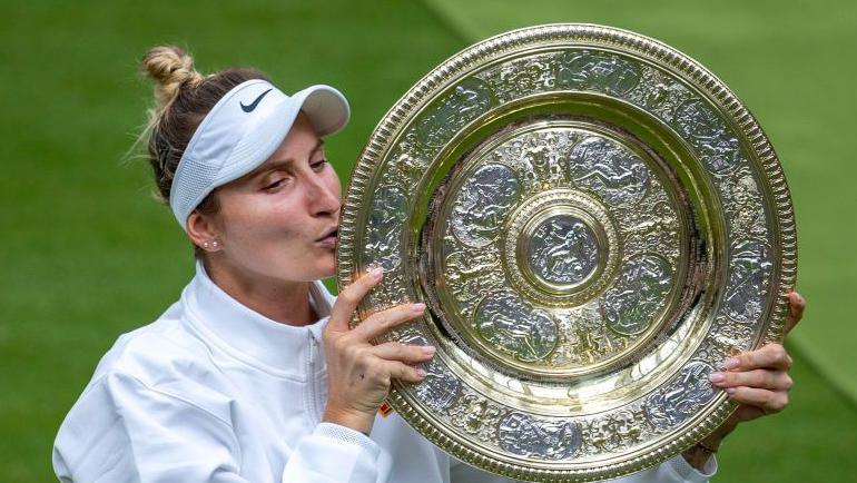Marketa Vondrousova kisses the Venus Rosewater Dish at Wimbledon in 2023