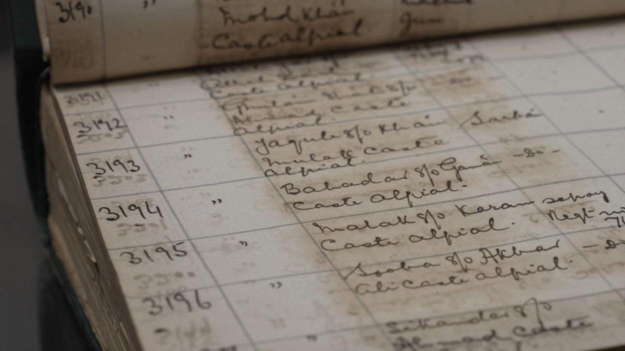 A large book is open, showing a table of handwritten entries of soliders from World War One