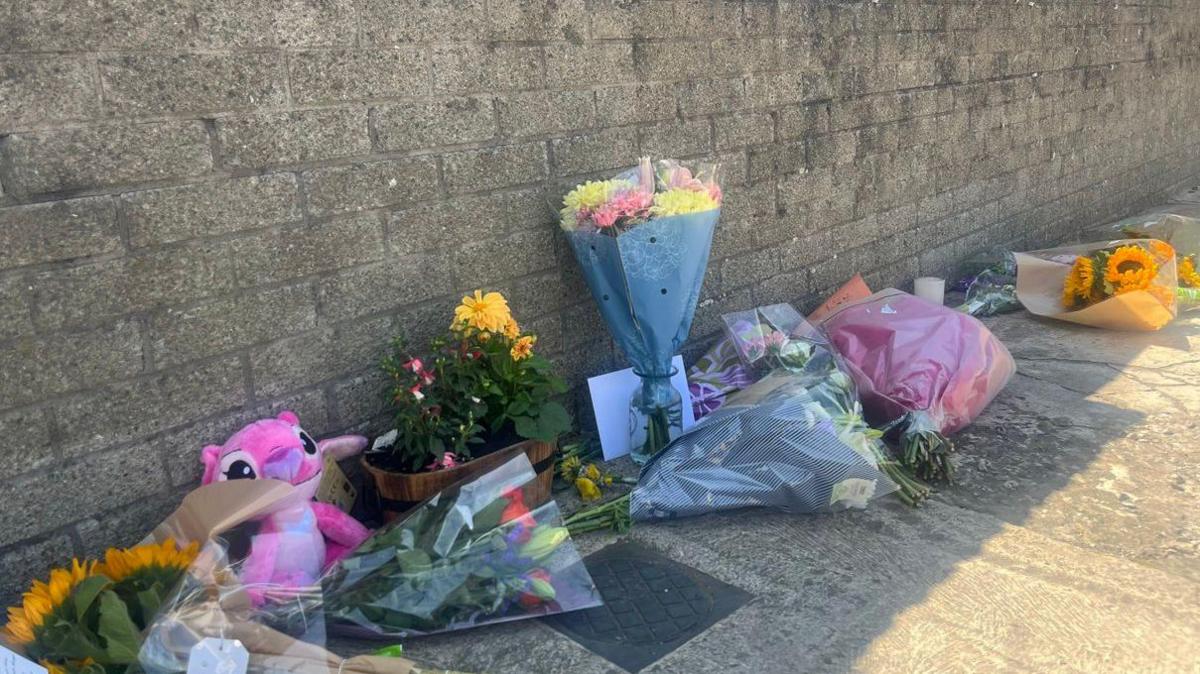 Bunches of flowers and a pink soft toy left at the scene of the killings