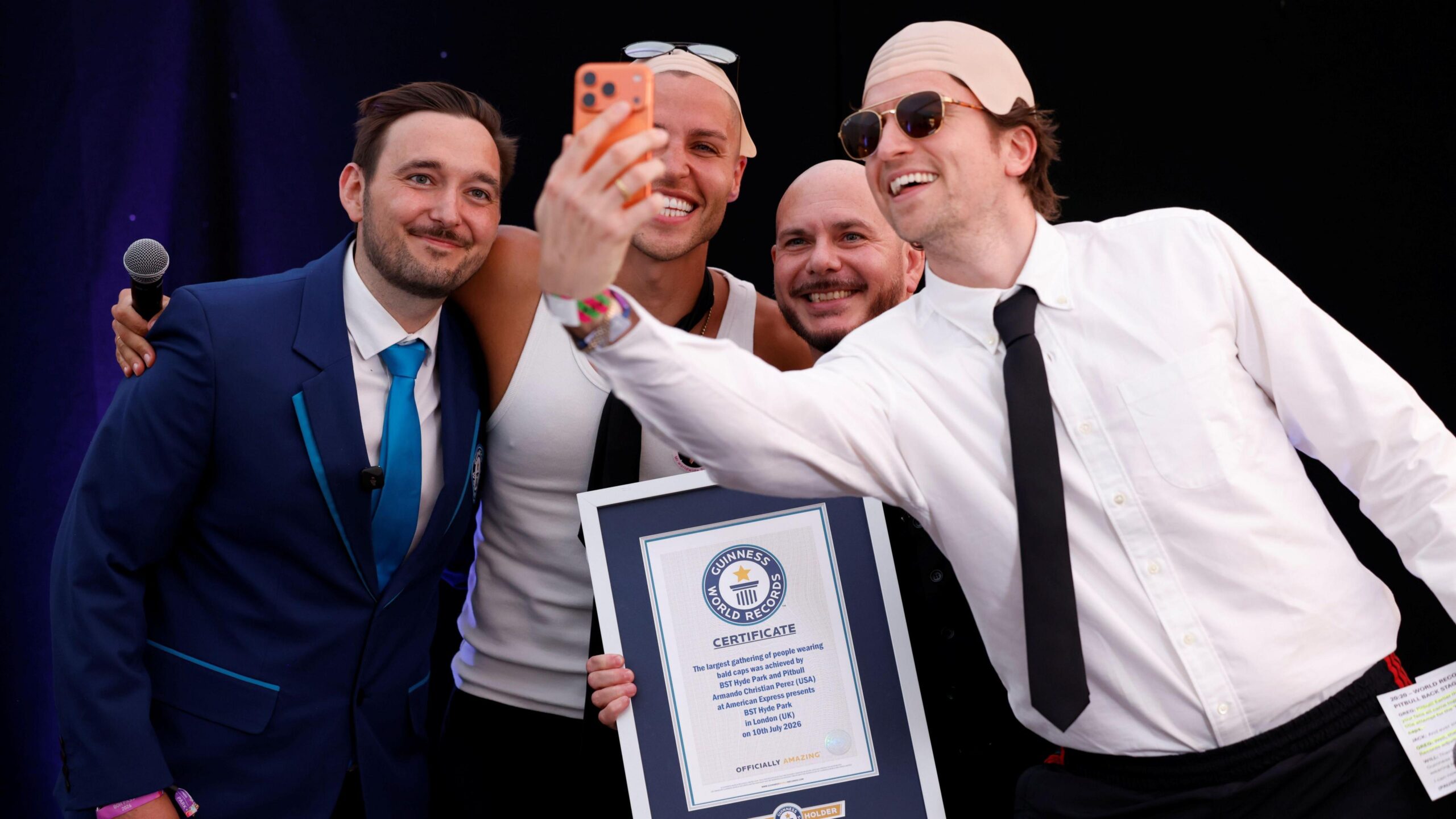 Guinness World Record ajudicator Will, content creator Jack Remmington, Pitbull and BBC Radio 1 Breakfast presenter Greg James pose for a selfie photo.