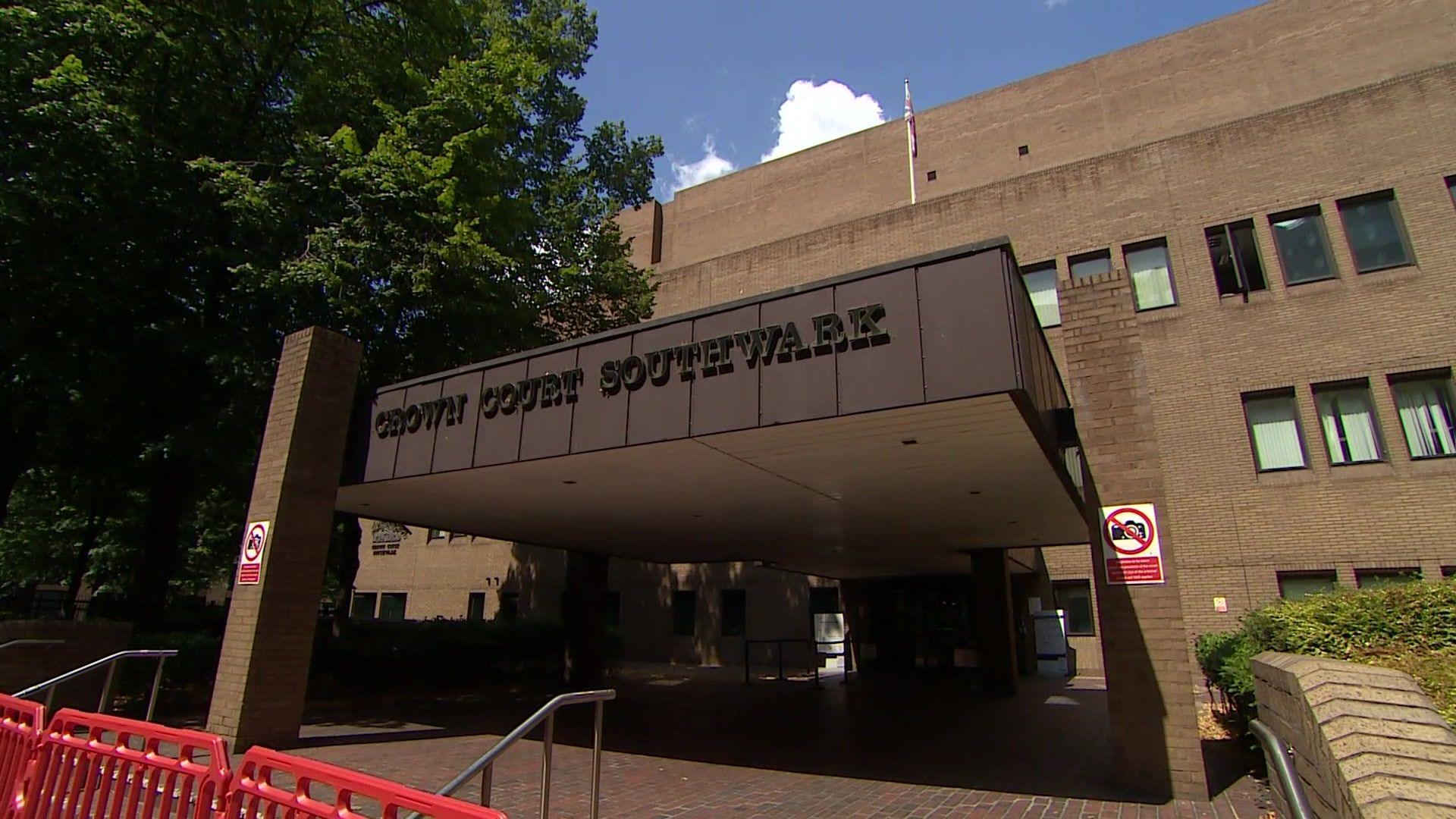 The exterior of a large court building with a porch and what is made of brown bricks.