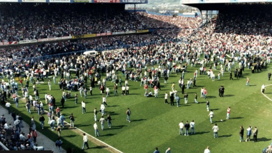 Image shows football fans, ambulances, paramedics and police officers on the pitch after the 1989 FA Cup semi-final at Hillsborough stadium was abandoned.