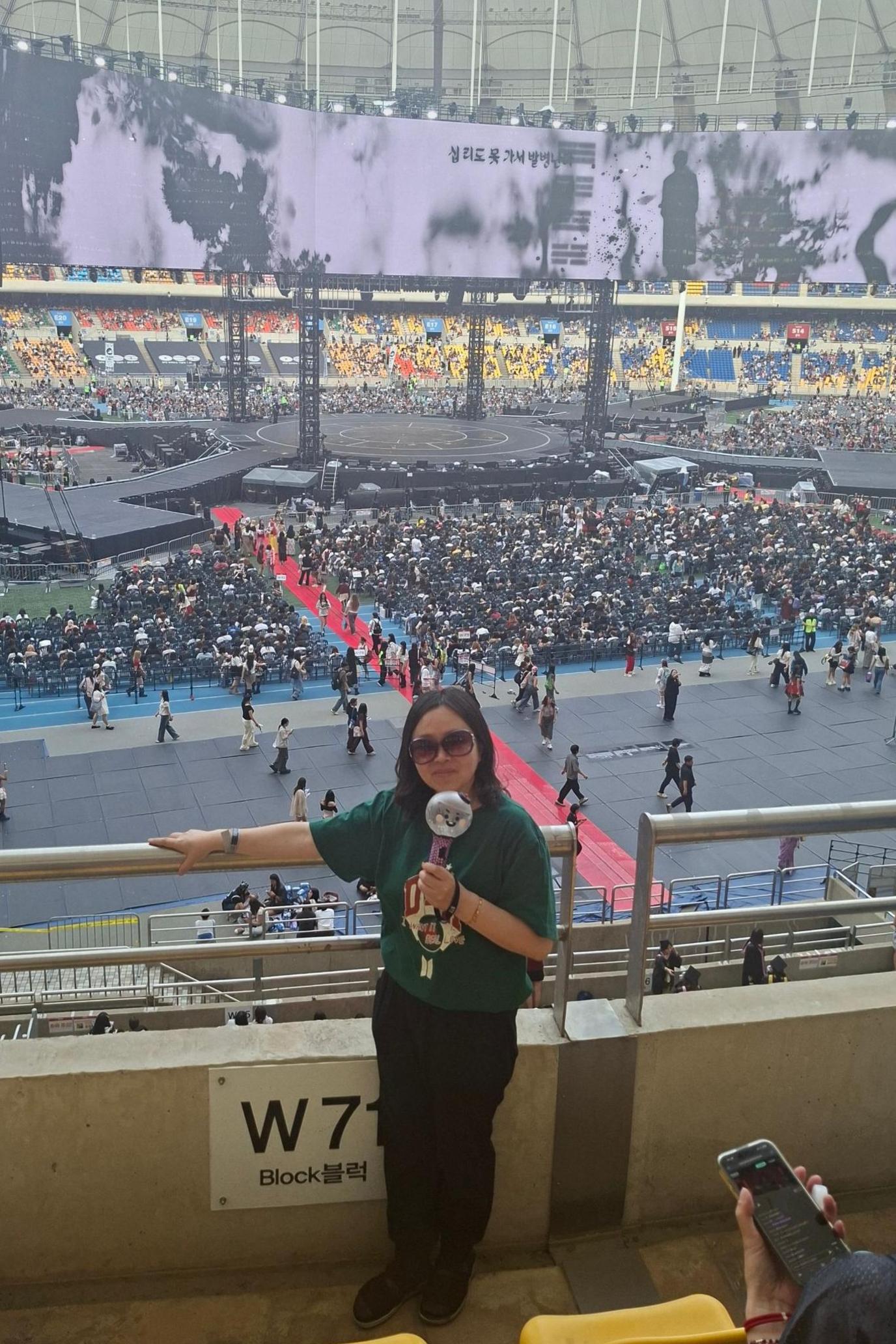 Yeon-su holds an Army Bomb, the official BTS light stick, during the group's World Tour concert in Busan.