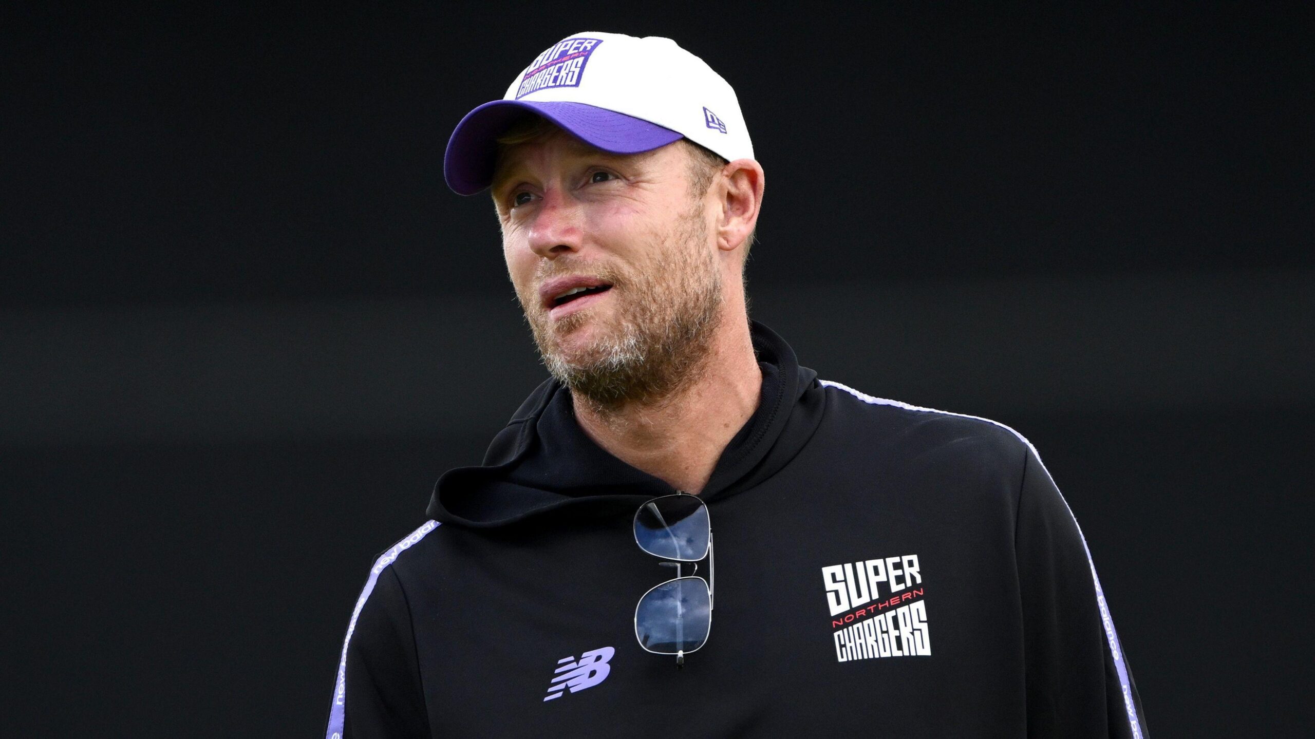 A bearded Andrew Flintoff in a Northern Superchargers black hooded top and white and purple cap