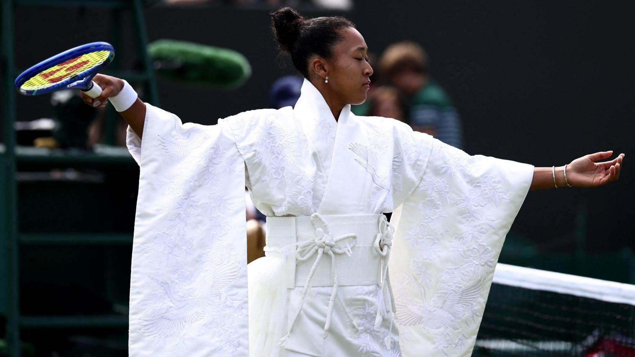 Naomi Osaka wears an all-white kimono as she prepares to warm up before her first-round match at Wimbledon