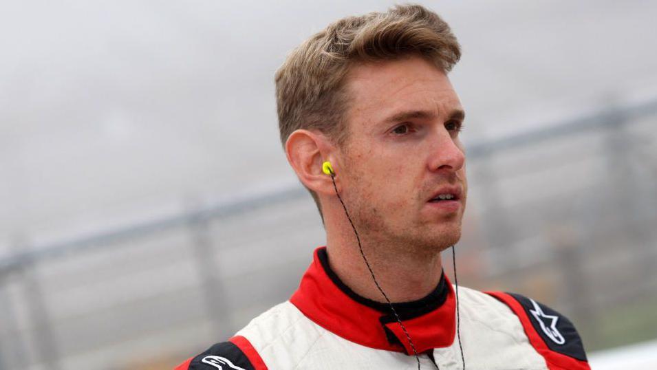 A close up of Paul Rees in a racing suit