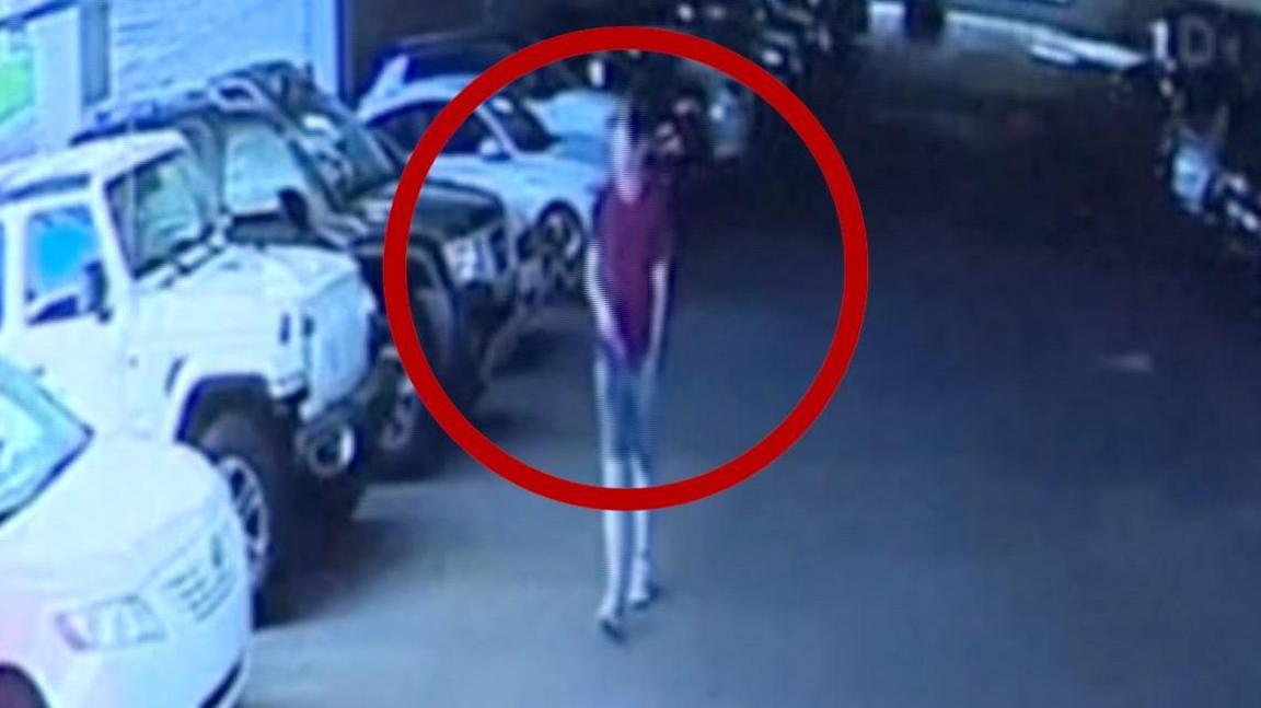 The alleged gunman in a maroon shirt, Converse shoes and gray or olive shorts