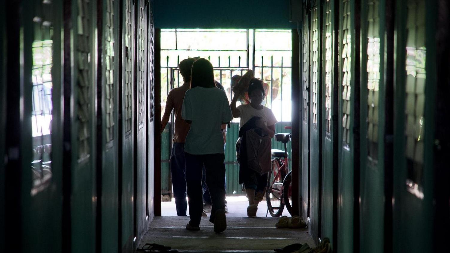 Burmese people stand at the end of a narrow corridor inside a cluster of safe houses in Thailand's Mae Sot town that borders Myanmar