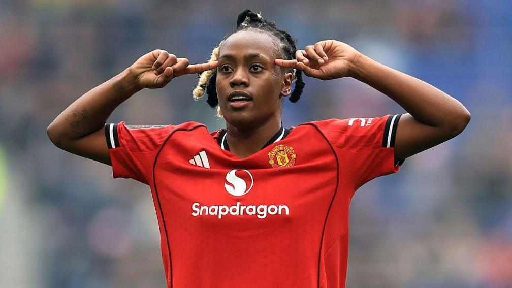 Melvine Malard points with both fingers to her head after scoring for Manchester United