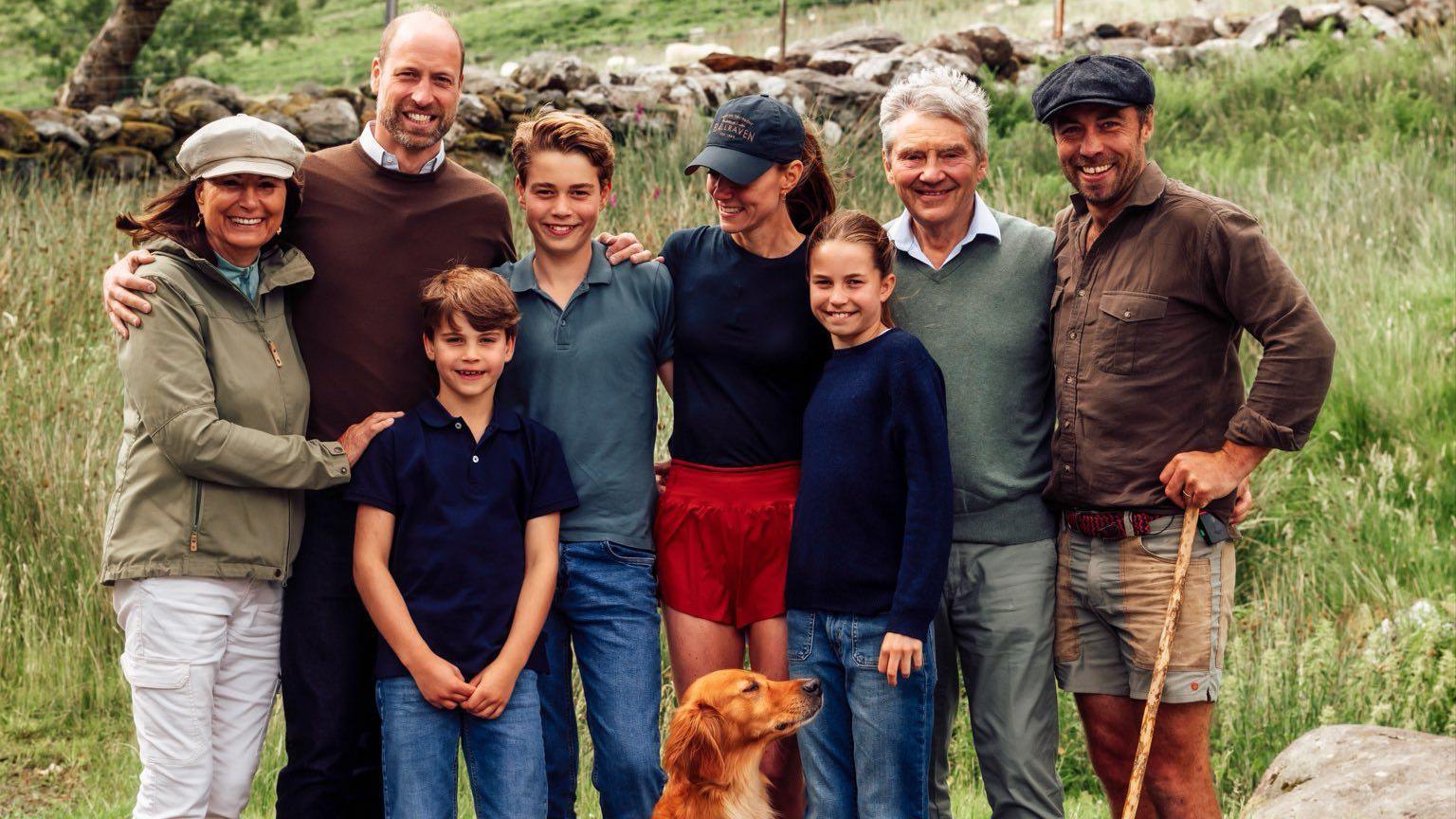 Catherine in the middle, next to her dad and son, husband, mum, brother and two other children. A golden retriever sits at their feet