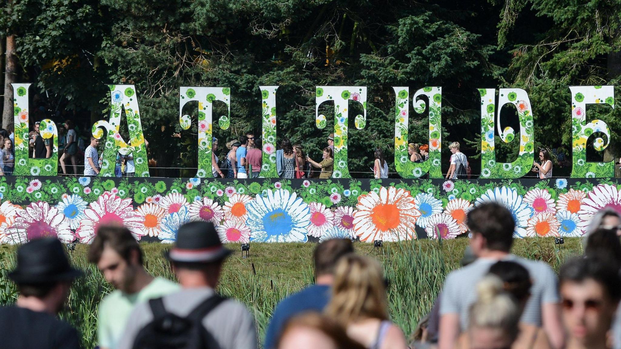 The famous flora Latitude Festival sign, In the foreground there are people with blurred faced.