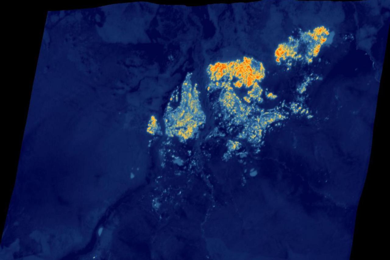 The satellite image shows flames in orange and yellow colours. The rest of the landscape is blue.