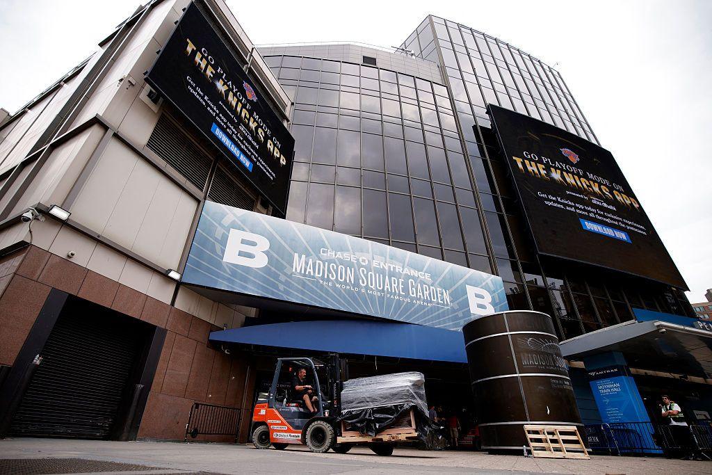 Outside Madison Square Garden, a person is seen driving a forklift with some equipment and bringing it into the venue. You can see the signage of the arena