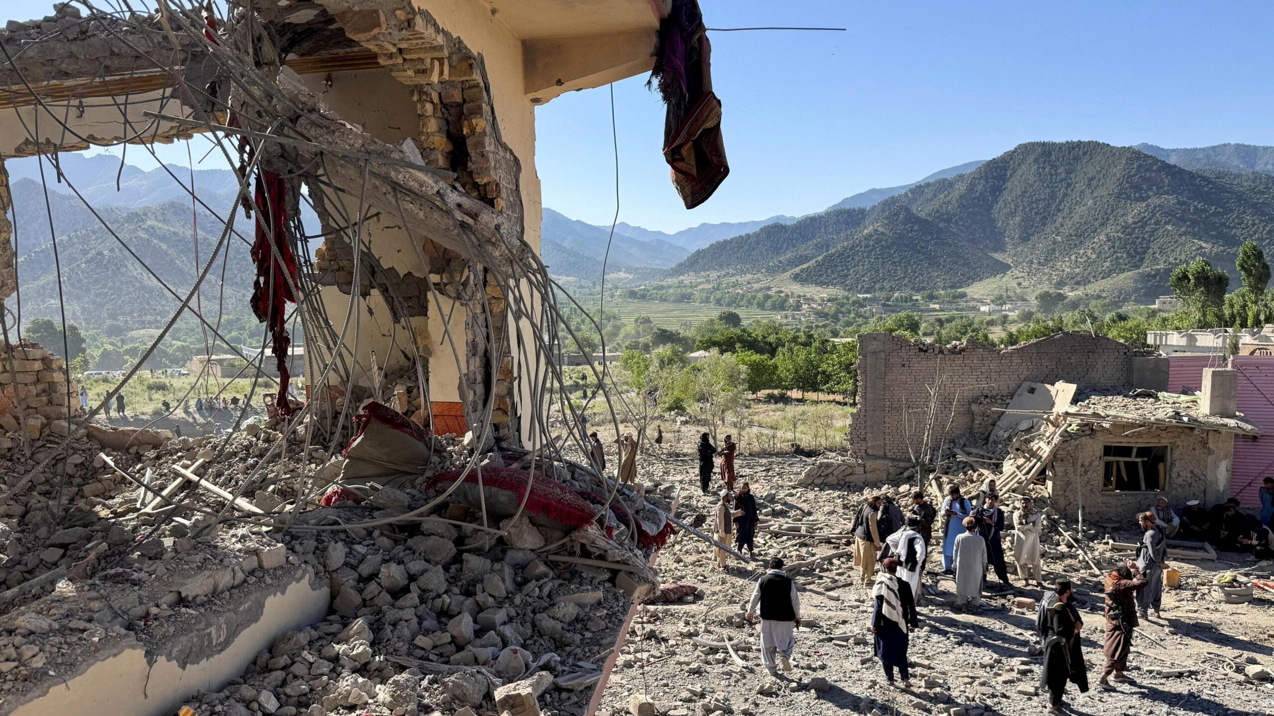 People inspect a damaged house at the site of Pakistani airstrikes in Mandokhail village in Paktia province, Afghanistan
