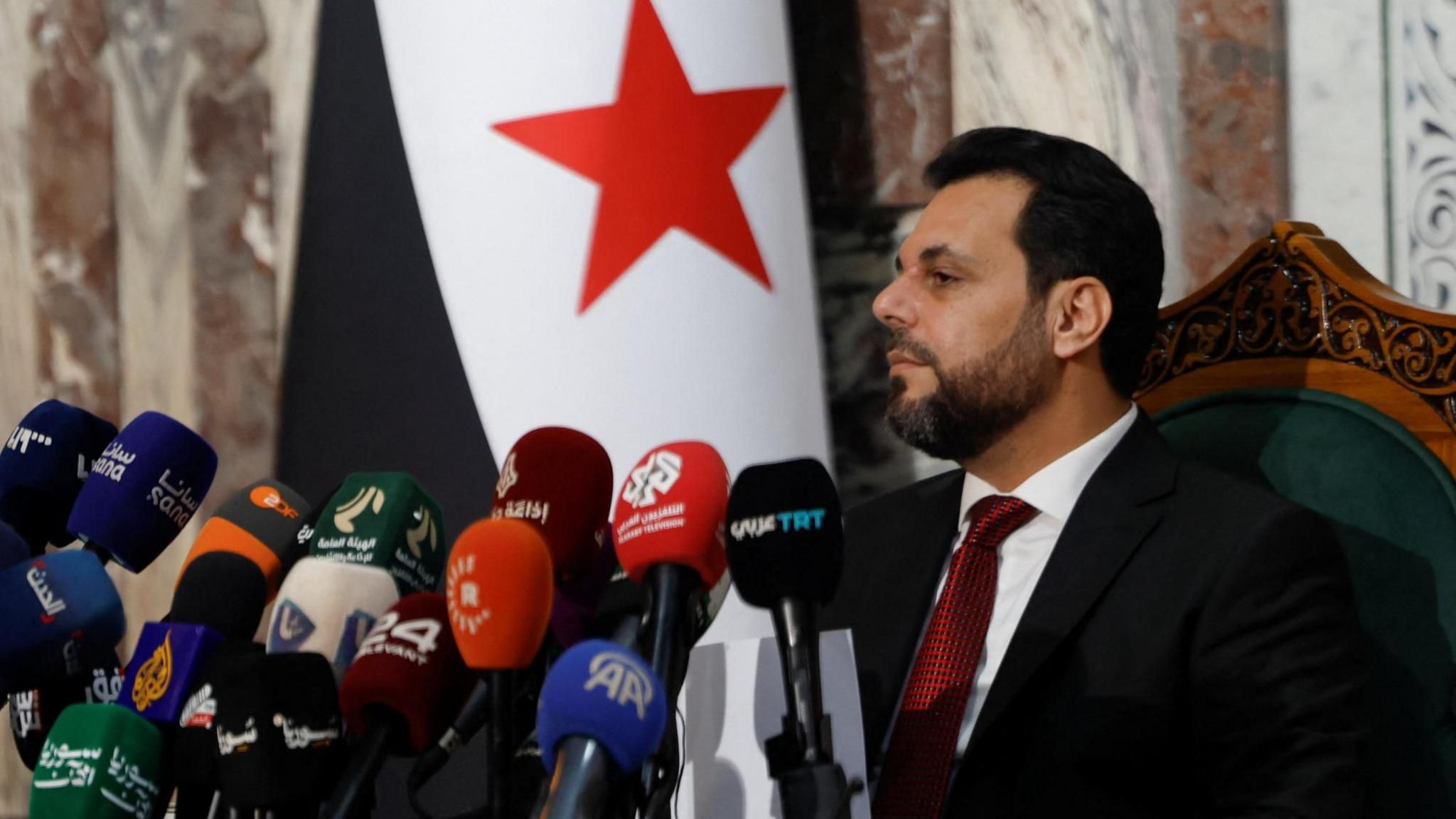 Mohammed Taha al-Ahmed (L), chairman of the Higher Committee for the Syrian People's Assembly Elections, listens during a news conference at the People's Assembly building in Damascus, Syria (1 July 2026)