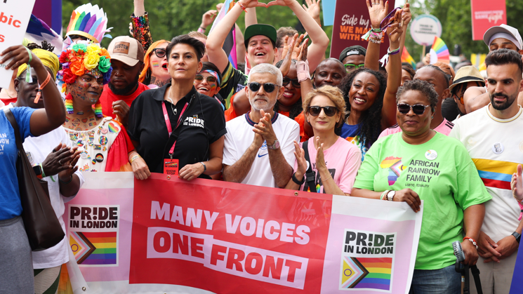 London Mayor Sadiq Khan in the centre of the shot. In front of him is a banner which reads Pride in London/Many Voices One Front. Other people stood with him are singer Beverley Knight, Dawn Butler MP, Saadiya Khan and Mete Çoban MBE