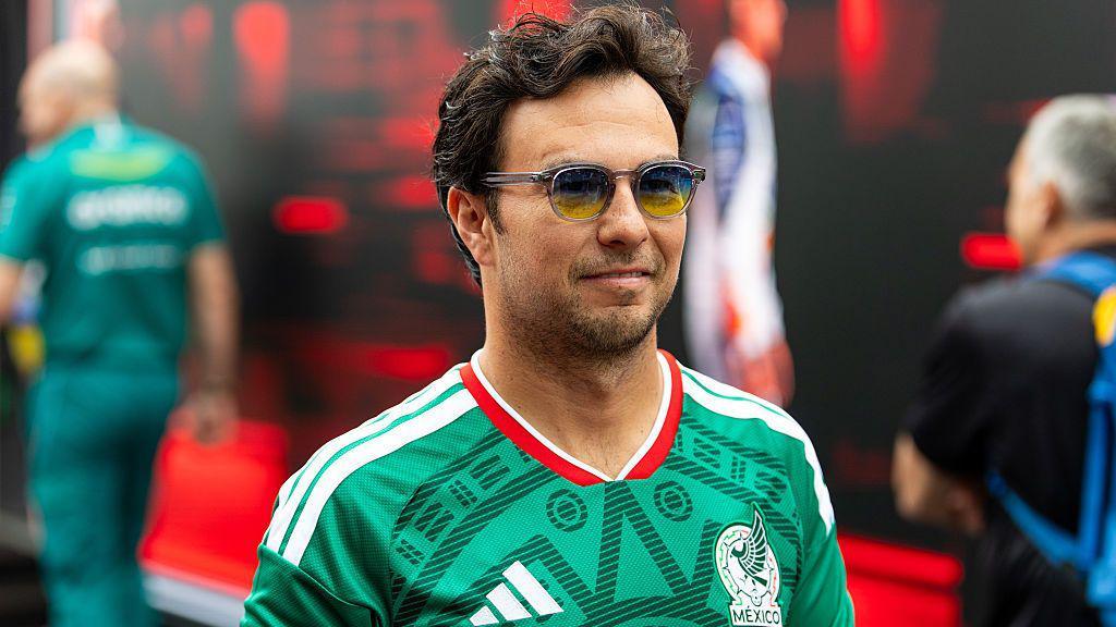 Sergio Perez wearing a Mexico football jersey in the paddock before the British Grand Prix