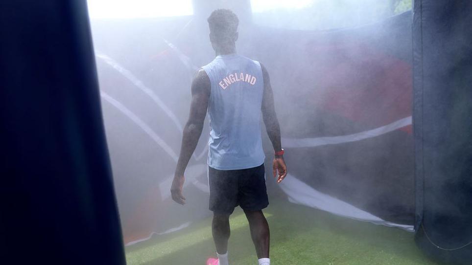 Bukayo Saka of England uses the cooling tent during an England training session
