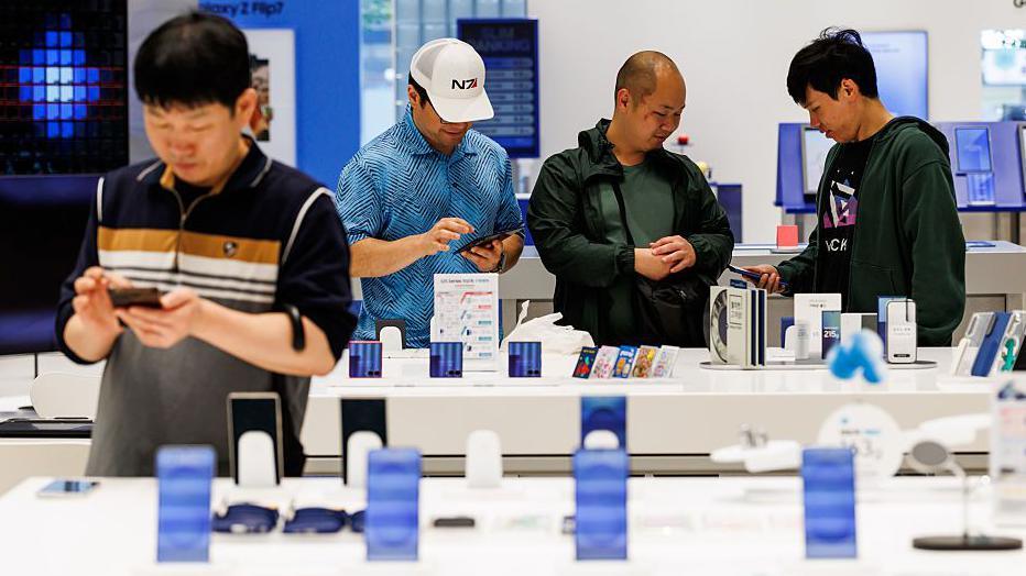 Customers try Samsung smartphones at one of the company's stores in Seoul