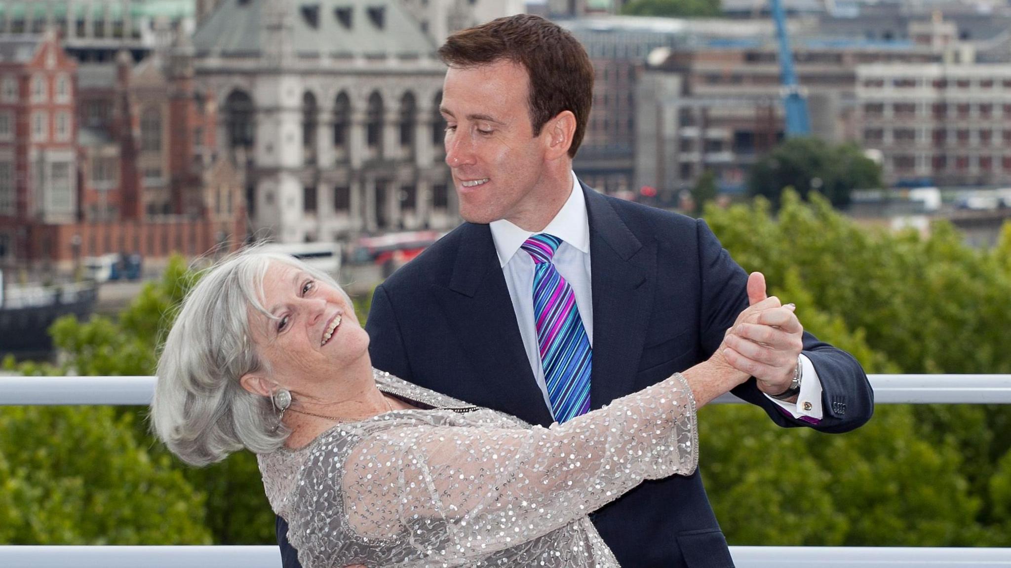 Ann Widdecombe dances with Anton du Beke in a ballroom pose with London skyline in background