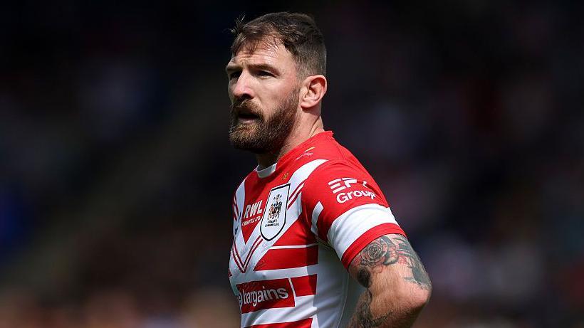 St Helens hooker Daryl Clark, in red and white,  has hands on hips as he watches play develop.