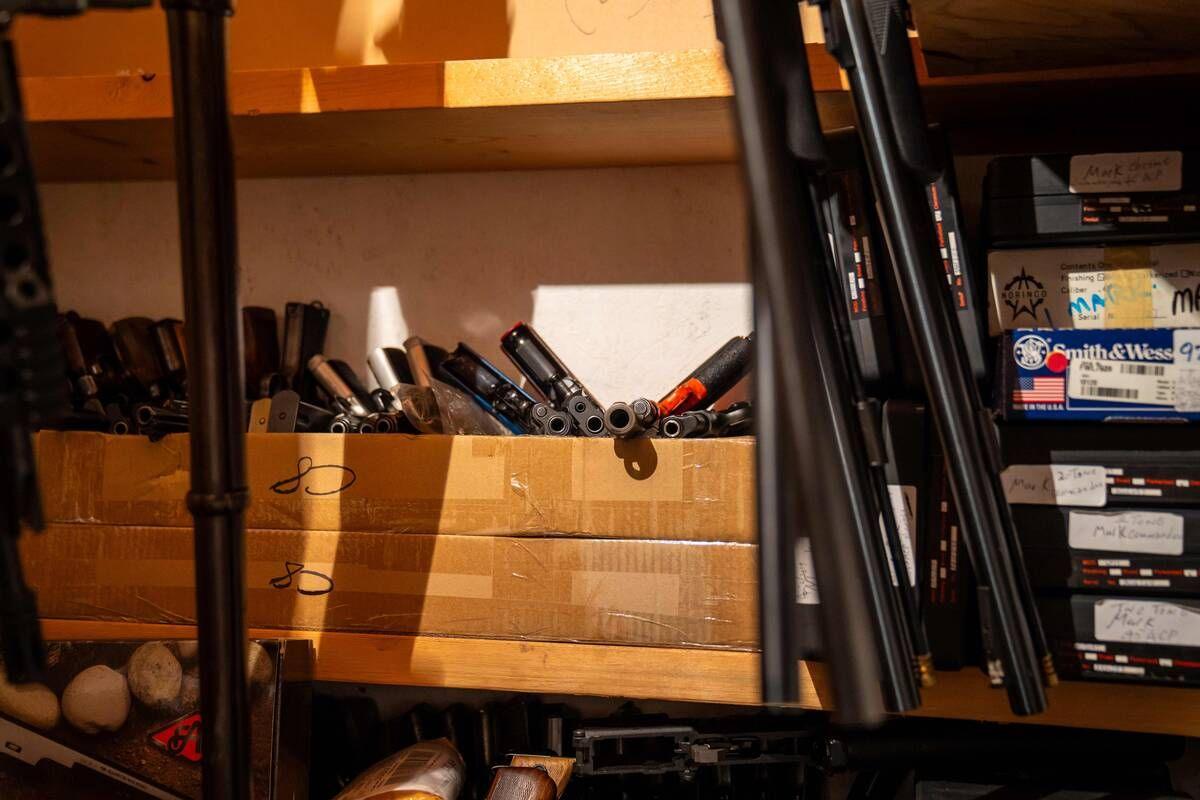 Firearms and ammunition are store on shelves in what appears to be a closet in a Dauphin, Manitoba home.
