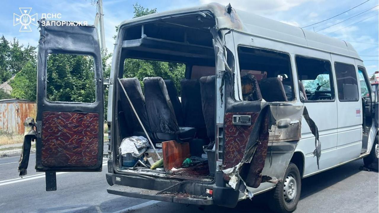 A white bus that used to carry civilians was hit by a drone. The back of the bus is blown open and the doors and seats are damaged.