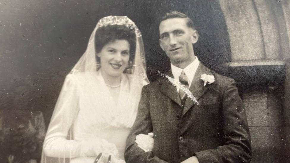 A black and white image of a man and a woman on their wedding day