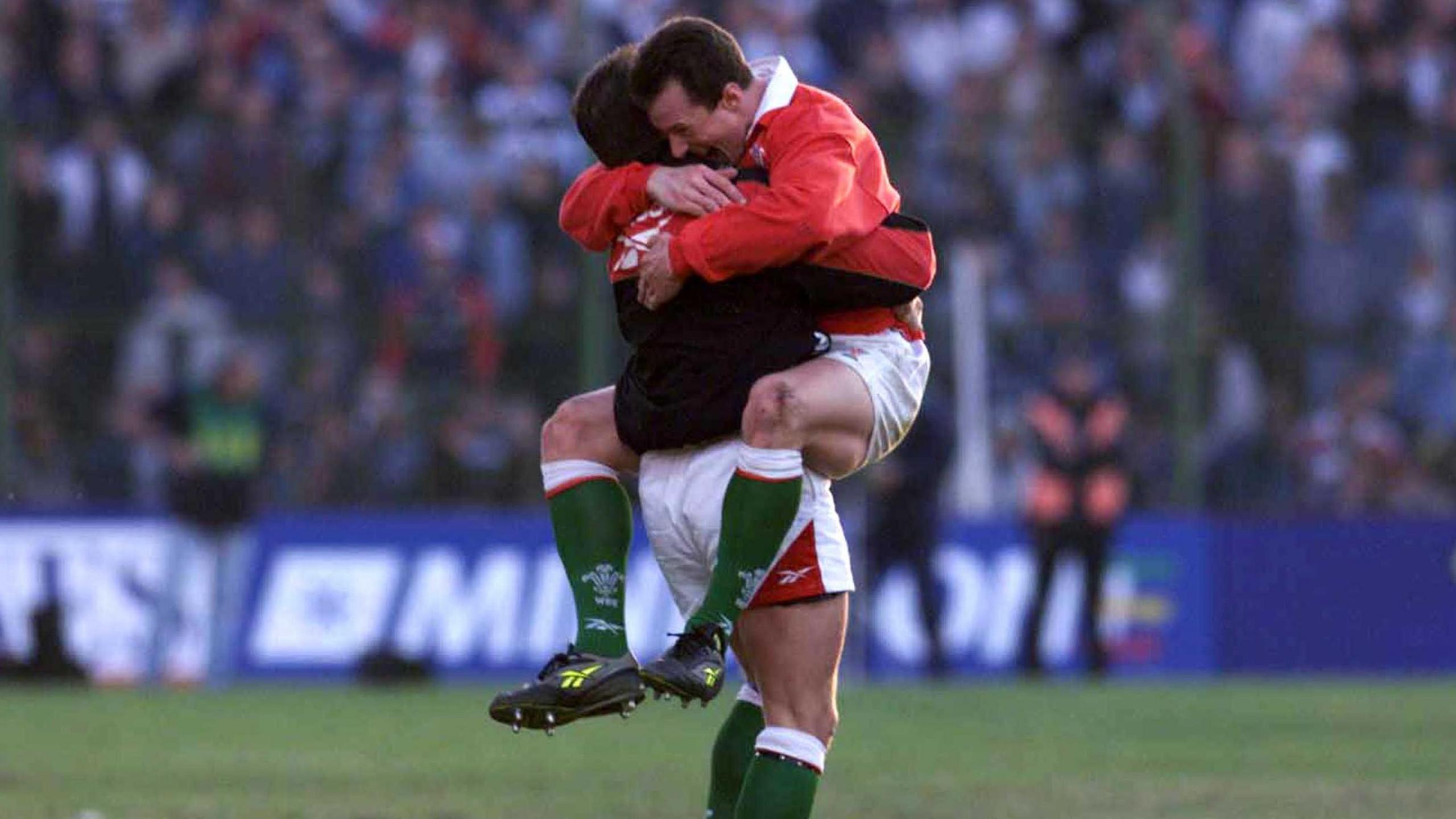 Rob Howley off the ground hugs a Wales team-mate on the successful tour of Argentina in 1999
