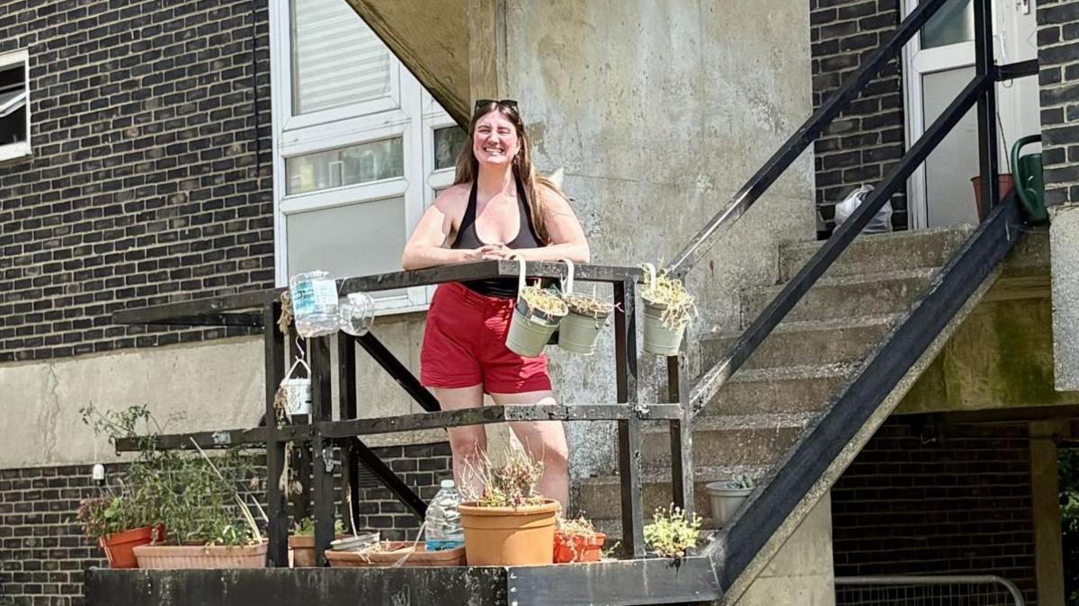 Katrina Woolley outside a 1960s style residential block