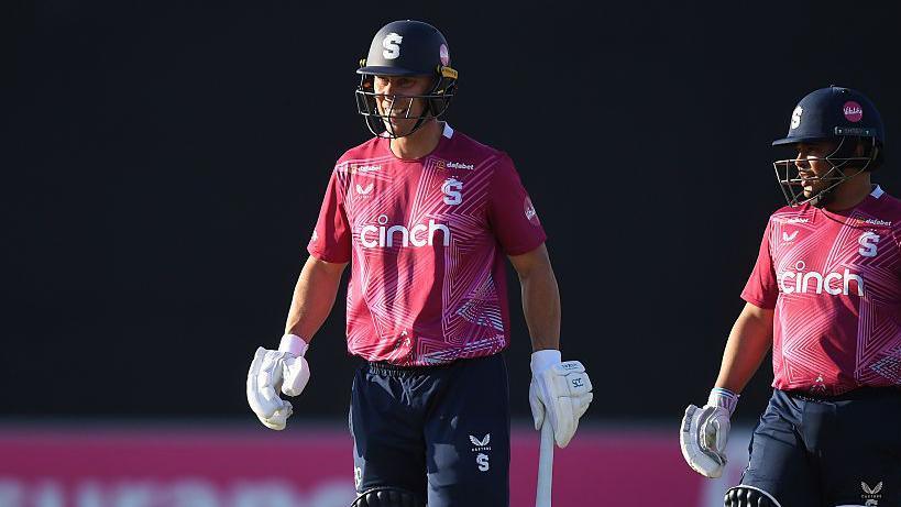 Chris Lynn, wearing a navy blue helmet and red shirt, leaves the field looking stern after being stuck on the toe during the quarter-final against Gloucestershire.