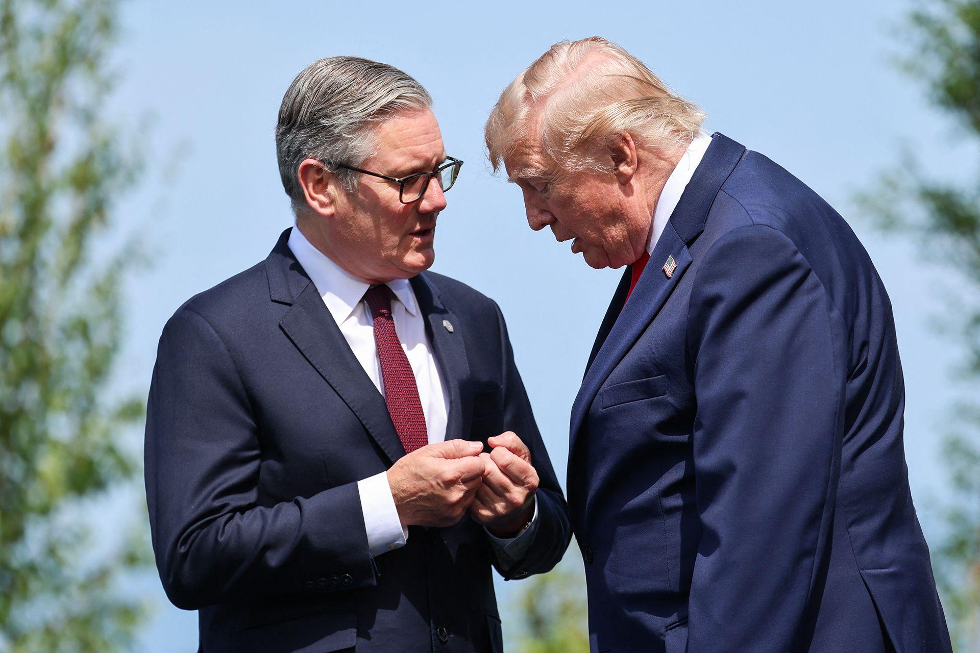 Britain's Prime Minister Keir Starmer and US President Donald Trump speak during a family photograph during the G7 summit, in Evian, eastern France, on June 16, 2026.