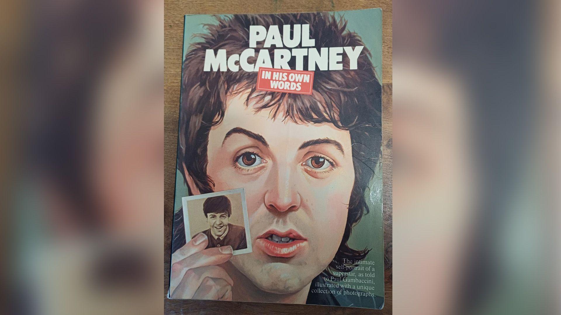Front cover of the Paul McCartney book. It has a cartoon image of Paul McCartney holding a photo inset of himself.