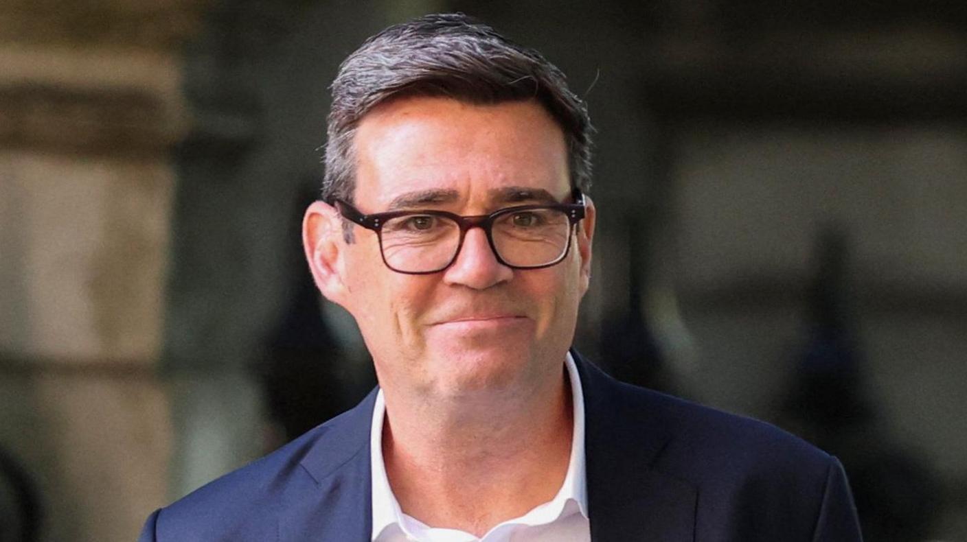 Andy Burnham pictured wearing a white shirt and dark suit