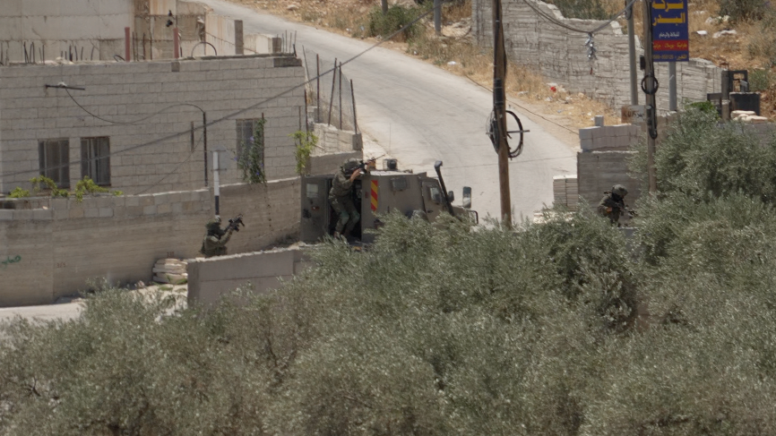 Israeli forces aim the rifles from behind a military vehicle in the Palestinian village of al-Mughayyir, near Ramallah, in the Israeli-occupied West Bank (11 July 2026)