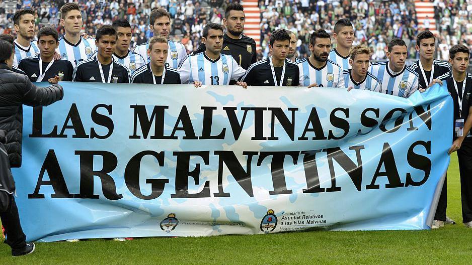 Argentina's footballers pose for photographers holding a banner reading "The Malvinas are Argentine" before a friendly football match against Slovenia