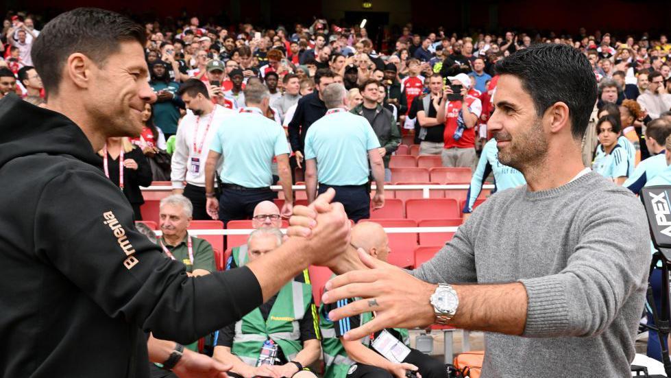 Xabi Alonso, Head Coach of Bayer 04 Leverkusen, interacts with Mikel Arteta, Manager of Arsenal, prior to the pre-season friendly match between Arsenal and Bayer 04 Leverkusen at Emirates Stadium