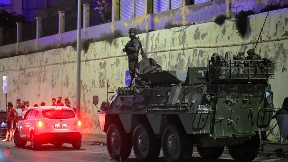 panish military stands guard at the border between the Spanish enclave of Ceuta and Morocco