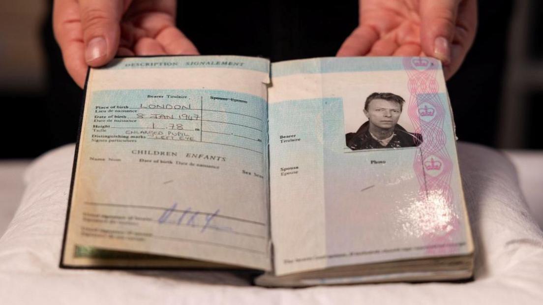 An opened page from David Bowie's 1988 British passport. It includes his date of birth, height, and a photo of Bowie