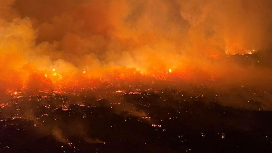 An evening picture of flames burning across dry land