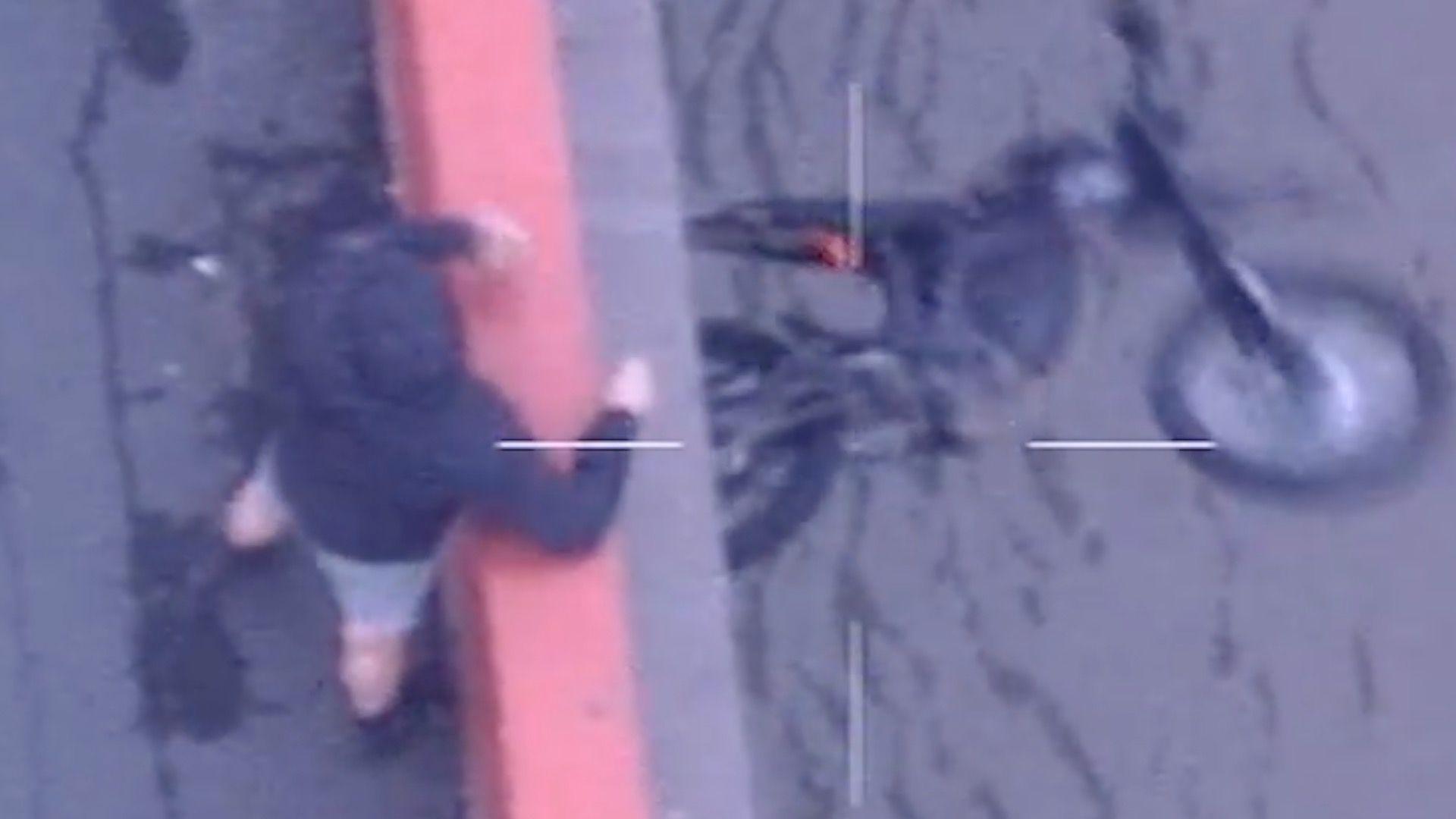 A man is seen throwing a bike off a bridge
