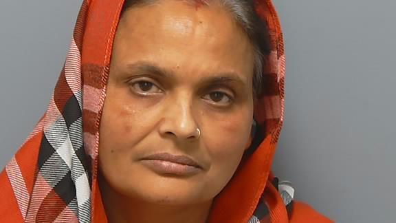 Kiran Kaur looking at the camera, with a red checked head scarf on on her head.