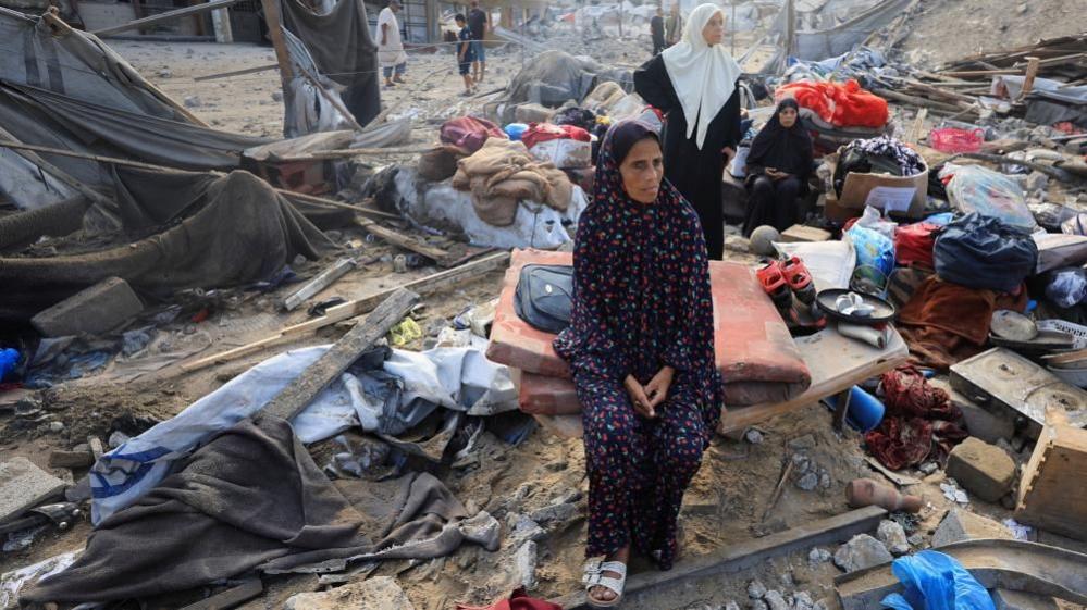 Palestinians inspect the site of Wednesday's Israeli strike on a house whose residents were pre-warned by the Israeli military to evacuate, in Gaza City