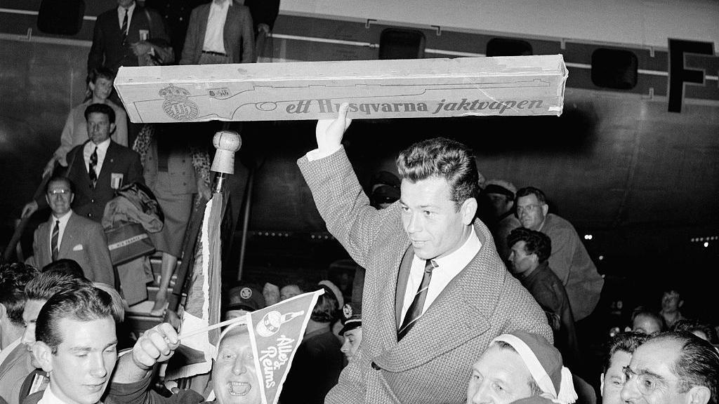 Just Fontaine holds aloft the air rifle given to him by a Swedish newspaper in honour of his scoring exploits