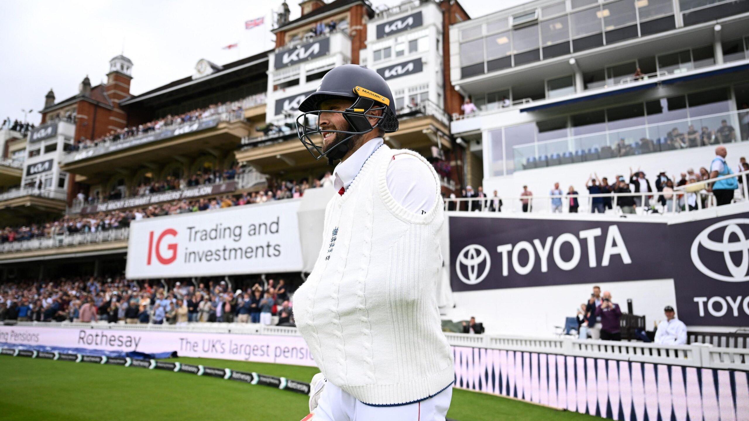 Chris Woakes walks out to bat at The Oval wearing a jumper over his left arm, which is in a sling